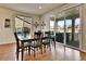 Elegant dining room with hardwood floors, modern table set, and large windows with sliding glass door to backyard at 10052 Isle St, Parker, CO 80134