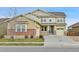 Charming two-story home with tan siding, brick accents, attached garage, and well-manicured lawn on a sunny day at 10052 Isle St, Parker, CO 80134