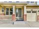 Inviting front porch with brick columns and neutral-colored door adjacent to attached garage for convenient access at 10052 Isle St, Parker, CO 80134