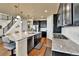 Modern kitchen with stainless appliances, island with seating, and stylish black cabinetry, perfect for cooking and entertaining at 10052 Isle St, Parker, CO 80134