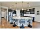Spacious kitchen featuring a large island, stainless steel appliances, hardwood floors and modern pendant lighting at 10052 Isle St, Parker, CO 80134