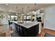 Open-concept kitchen with an oversized island featuring pendant lighting, stainless steel appliances and hardwood floors at 10052 Isle St, Parker, CO 80134