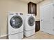 Well-lit laundry room with front load washer and dryer and storage cabinets at 10052 Isle St, Parker, CO 80134