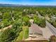 Aerial view showcases a home with lush greenery, landscaping, and neighborhood charm at 1420 W Ridge Rd, Littleton, CO 80120