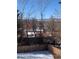 View from the backyard showing the home, trees, and surrounding landscape in winter at 1420 W Ridge Rd, Littleton, CO 80120