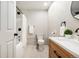 Modern bathroom with updated vanity, shower/tub with white shower curtain, neutral tile, and updated fixtures at 1420 W Ridge Rd, Littleton, CO 80120