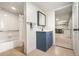 Bathroom with a shower-tub combo and blue vanity by a doorway at 1420 W Ridge Rd, Littleton, CO 80120