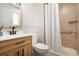 Bathroom with wood vanity, black faucet, shower with tile surround, and accessibility bar at 1420 W Ridge Rd, Littleton, CO 80120