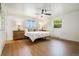 Bright primary bedroom boasts wood-look floors, large windows, and ceiling fan for a light and airy feel at 1420 W Ridge Rd, Littleton, CO 80120