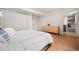 Clean bedroom with light wood floors, white duvet, and natural light at 1420 W Ridge Rd, Littleton, CO 80120