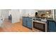 Open concept kitchen with stainless appliances and stylish cabinetry, with living room in the background at 1420 W Ridge Rd, Littleton, CO 80120
