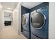 Modern laundry room with side-by-side blue washer and dryer at 1420 W Ridge Rd, Littleton, CO 80120