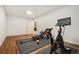 Basement workout room with wood floors and exercise equipment by a door at 1420 W Ridge Rd, Littleton, CO 80120
