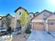 Inviting townhome with a two-car garage and a manicured front yard with decorative trees and bushes at 11983 W Long Cir # 203, Littleton, CO 80127