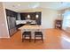 Stylish kitchen featuring dark wood cabinets, an island with seating, and stainless steel appliances at 11983 W Long Cir # 203, Littleton, CO 80127
