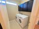 Bright laundry room with a washer and dryer, and built-in cabinets for added storage at 11983 W Long Cir # 203, Littleton, CO 80127
