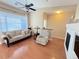 Bright living room with hardwood floors, comfortable furniture, a ceiling fan, and a fireplace with a TV at 11983 W Long Cir # 203, Littleton, CO 80127