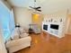 Cozy living room with hardwood floors, a fireplace, a ceiling fan, and comfortable seating at 11983 W Long Cir # 203, Littleton, CO 80127