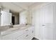 Bathroom features double sinks, white cabinets and a large mirror at 1448 Orchard St, Brighton, CO 80601