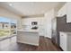 Bright kitchen with white cabinets, stainless steel appliances, center island, dark wood floors, and a sliding glass door at 1448 Orchard St, Brighton, CO 80601