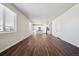 Spacious living room featuring dark wood floors and an open layout to a bright kitchen at 1448 Orchard St, Brighton, CO 80601