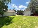 Spacious backyard featuring lush green grass, a deck, storage shed, and a detached garage at 6484 S Datura St, Littleton, CO 80120