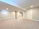 Spacious basement with neutral carpet, stairs to upper level, and a white door at 6484 S Datura St, Littleton, CO 80120