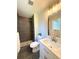 Bathroom with gray tiled shower, marble vanity, and modern fixtures at 6484 S Datura St, Littleton, CO 80120