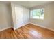 Bright bedroom with hardwood floors, a large window, and neutral walls at 6484 S Datura St, Littleton, CO 80120