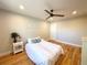 Comfortable bedroom featuring light hardwood floors, a ceiling fan, and a large window at 6484 S Datura St, Littleton, CO 80120