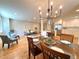 Dining room with hardwood floors, chandelier, and open view into the living room and kitchen at 6484 S Datura St, Littleton, CO 80120