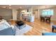 Open-concept living and dining area with hardwood floors and modern lighting fixtures at 6484 S Datura St, Littleton, CO 80120