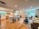 Bright, open-concept living space featuring hardwood floors, recessed lighting, and a modern kitchen island at 6484 S Datura St, Littleton, CO 80120