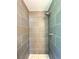 Updated shower with gray tiling and a modern shower head at 6484 S Datura St, Littleton, CO 80120