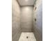 Modern shower with gray tiling and a mosaic tile floor at 6484 S Datura St, Littleton, CO 80120