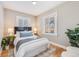 Comfortable bedroom with two bright windows, hardwood floors, and minimalist decor with plant accents at 3451 N York St, Denver, CO 80205