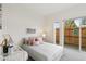 Bright bedroom with a gray quilted bedspread, pink pillows, and sliding glass doors to the backyard at 5367 W 14Th Ave, Lakewood, CO 80214