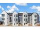 Modern townhome featuring a gray and white exterior with a well-manicured lawn and blue sky at 5367 W 14Th Ave, Lakewood, CO 80214