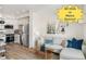Bright living room featuring an open floor plan, white cabinets, stainless appliances, and modern decor at 5367 W 14Th Ave, Lakewood, CO 80214
