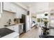 Bright living space and kitchen features hardwood floors, white walls, simple decor, and lots of light at 5367 W 14Th Ave, Lakewood, CO 80214
