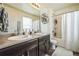 Bathroom featuring a dual sink vanity with a large mirror and combined bath/shower at 13644 Ulster St, Thornton, CO 80602