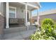 Inviting front porch with a comfortable bench, potted flowers, and classic architectural details at 13644 Ulster St, Thornton, CO 80602