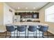 Modern kitchen with dark cabinets, stainless steel appliances, and a large island with seating at 13644 Ulster St, Thornton, CO 80602