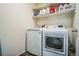 Laundry room featuring a front load washer and dryer and upper shelving at 13644 Ulster St, Thornton, CO 80602
