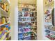 Walk-in pantry with ample shelving for organized food and household storage at 13644 Ulster St, Thornton, CO 80602