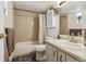Tiled bathroom features tub with shower, toilet, vanity with neutral countertop and decorative accents at 8060 E Girard Ave # 712, Denver, CO 80231
