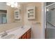 Bright bathroom featuring double sinks, wooden cabinets, and a shower with glass doors at 353 S Niagara St, Denver, CO 80224