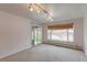 Living room with carpet, window, and access to back yard at 353 S Niagara St, Denver, CO 80224