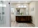 Gorgeous primary bathroom with dual sink granite counters, stylish fixtures, and frameless glass shower at 1848 W 68Th Ave, Denver, CO 80221