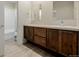 Bathroom featuring double sinks, vanity, framed mirrors, wood cabinets and a shower/tub combo at 1848 W 68Th Ave, Denver, CO 80221